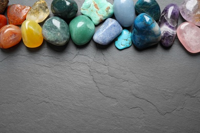 Photo of Flat lay composition with different gemstones on grey table, space for text