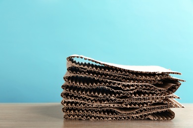 Photo of Stack of cardboard for recycling on table against color background. Space for text