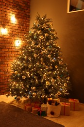 Photo of Beautiful Christmas tree with festive lights and gifts in living room. Interior design