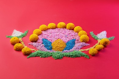 Photo of Happy Diwali. Composition with colorful rangoli and chrysanthemum flowers on red background