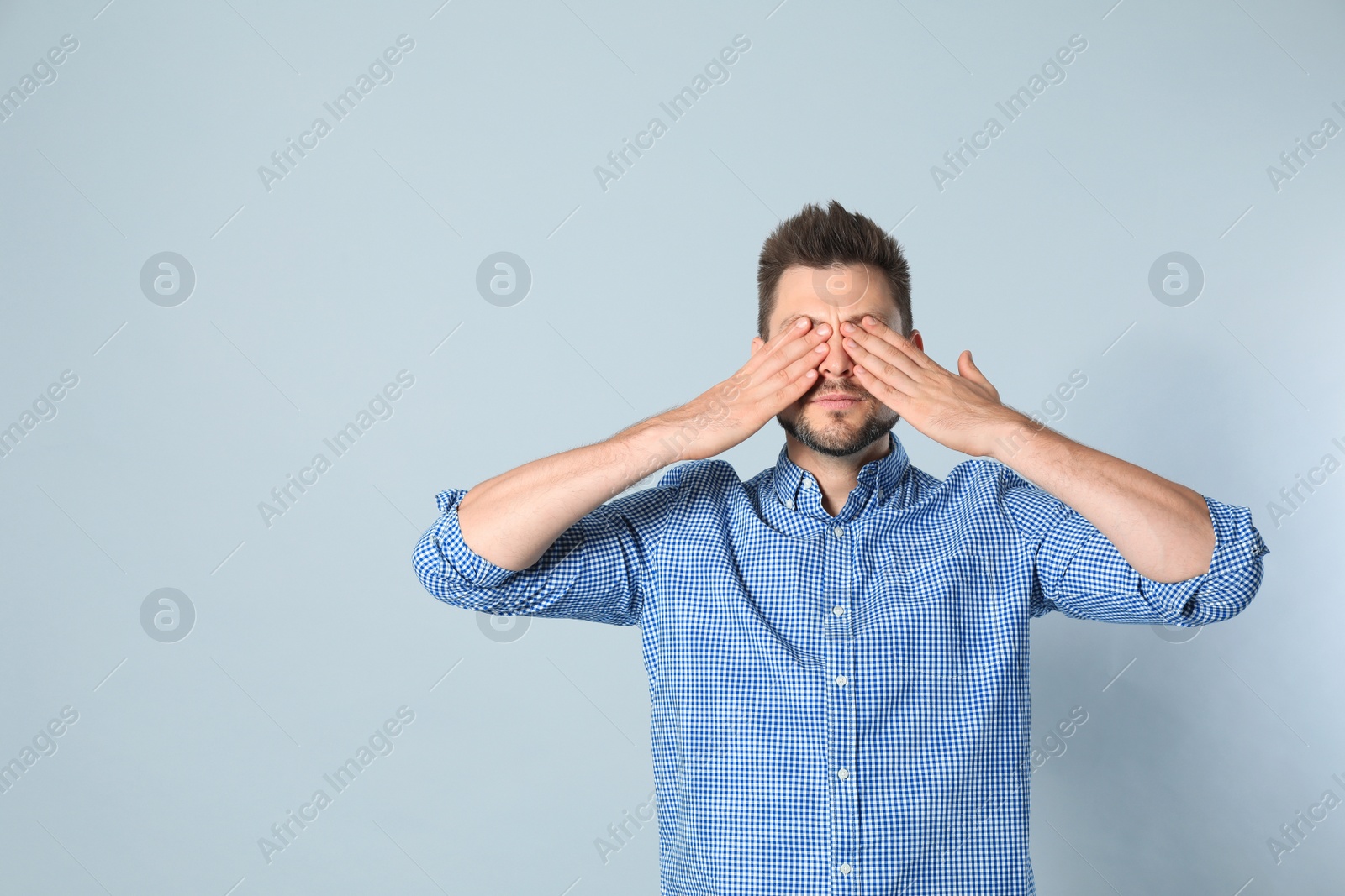Photo of Handsome man being blinded on grey background