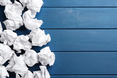 Crumpled sheets of paper on blue wooden background, flat lay. Space for text