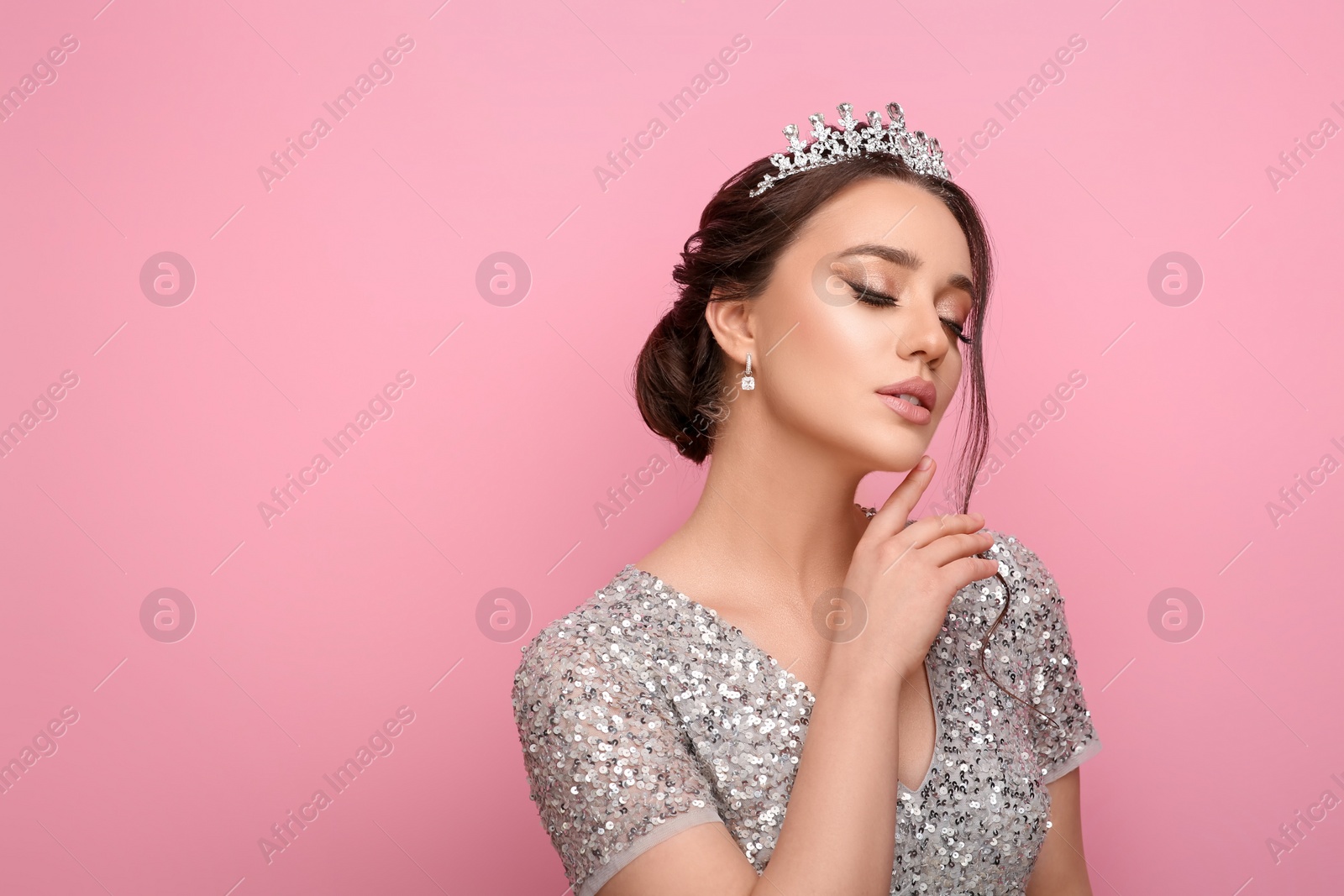 Photo of Beautiful young woman wearing luxurious tiara on pink background, space for text