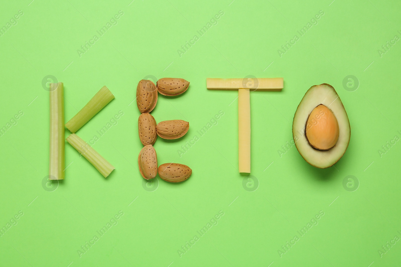 Photo of Word Keto made with different products on light green background, flat lay