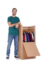 Young man near wardrobe box on white background