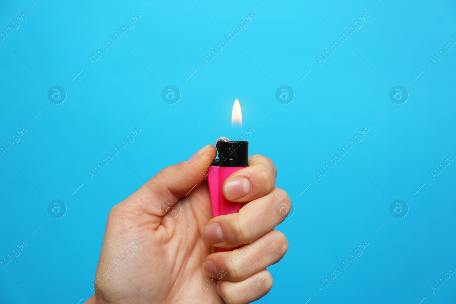 Photo of Woman holding pink lighter on light blue background, closeup