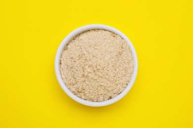Photo of Beer yeast flakes on yellow background, top view
