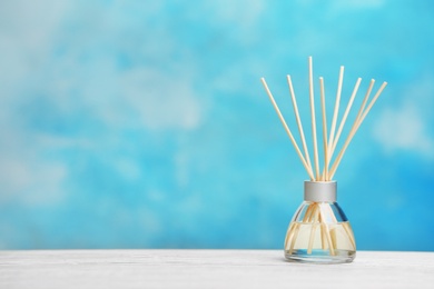 Aromatic reed freshener on table against color background