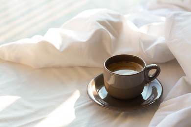 Photo of Aromatic morning coffee on bed, space for text
