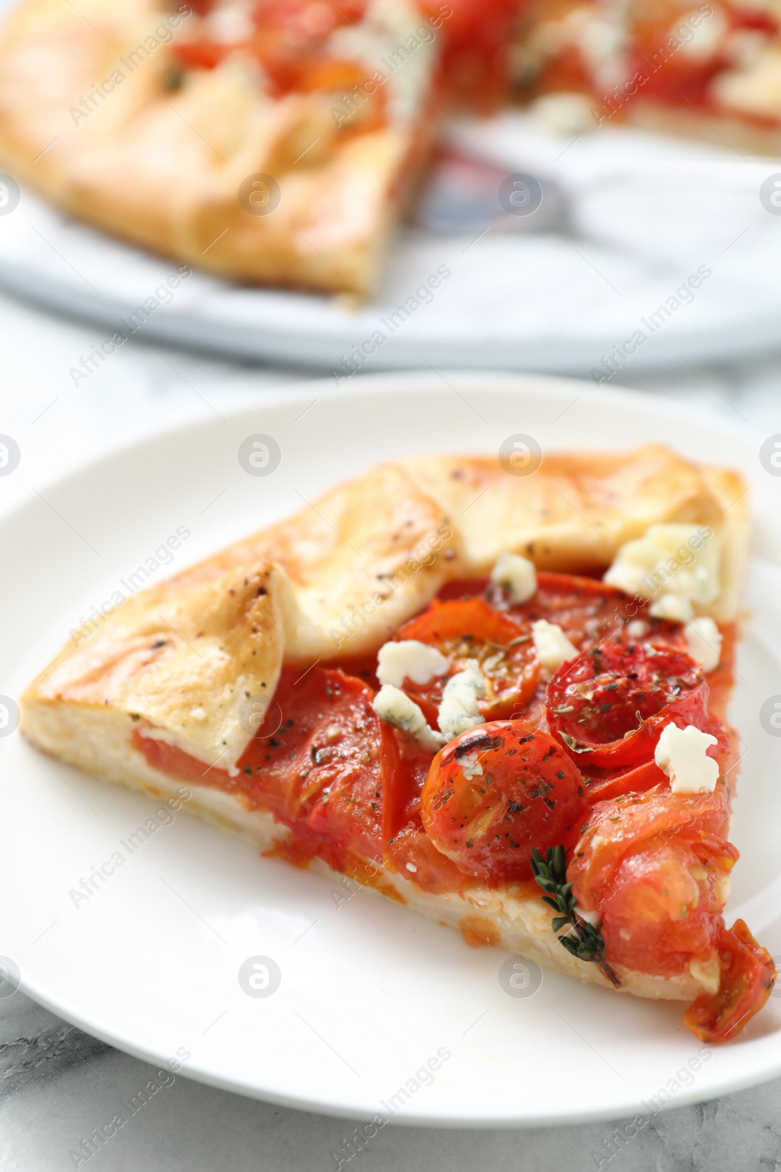 Photo of Tasty galette with tomato and cheese (Caprese galette) on white marble table, closeup