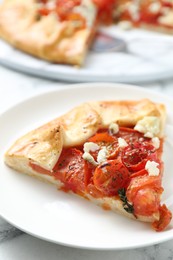 Photo of Tasty galette with tomato and cheese (Caprese galette) on white marble table, closeup