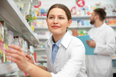 Image of Professional pharmacist near shelves in modern drugstore