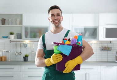 Photo of Portrait of janitor with bucket of detergents in kitchen. Cleaning service
