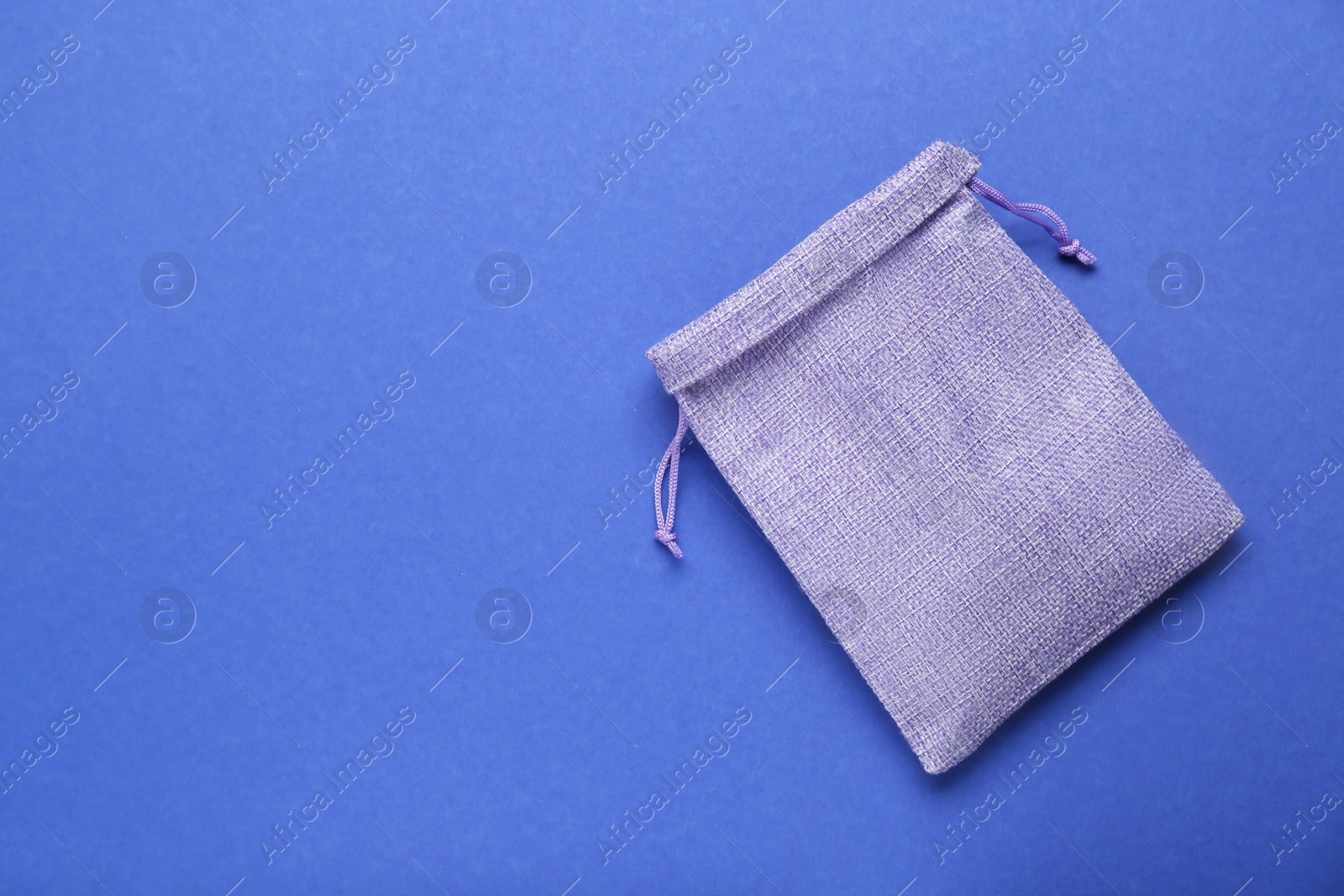 Photo of Violet burlap bag on blue background, top view. Space for text