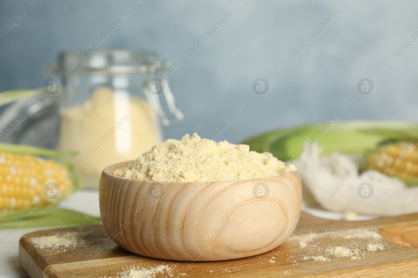 Photo of Corn flour in bowl on wooden board