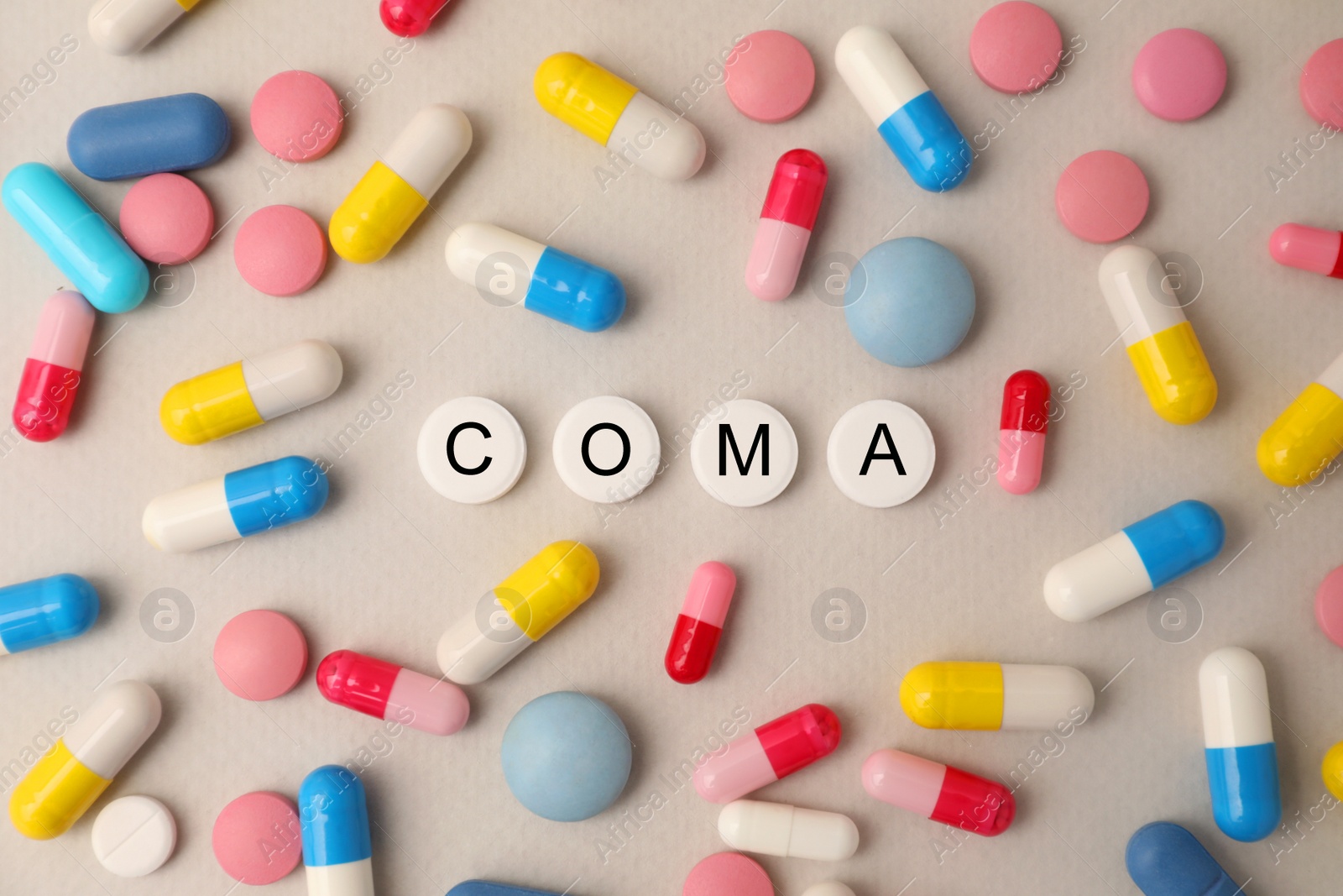 Photo of Pills with word Coma among others on beige background, flat lay