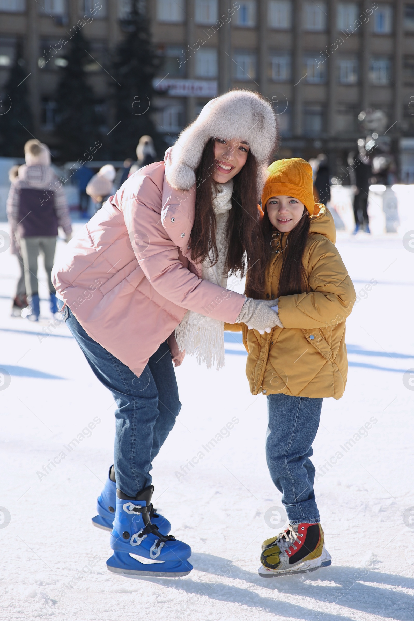 Image of Mother and daughter spending time together at outdoor ice skating rink