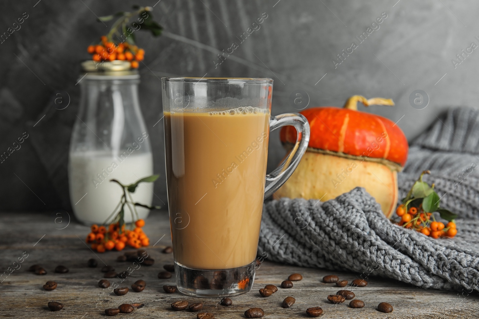 Photo of Composition with tasty pumpkin spice latte on table