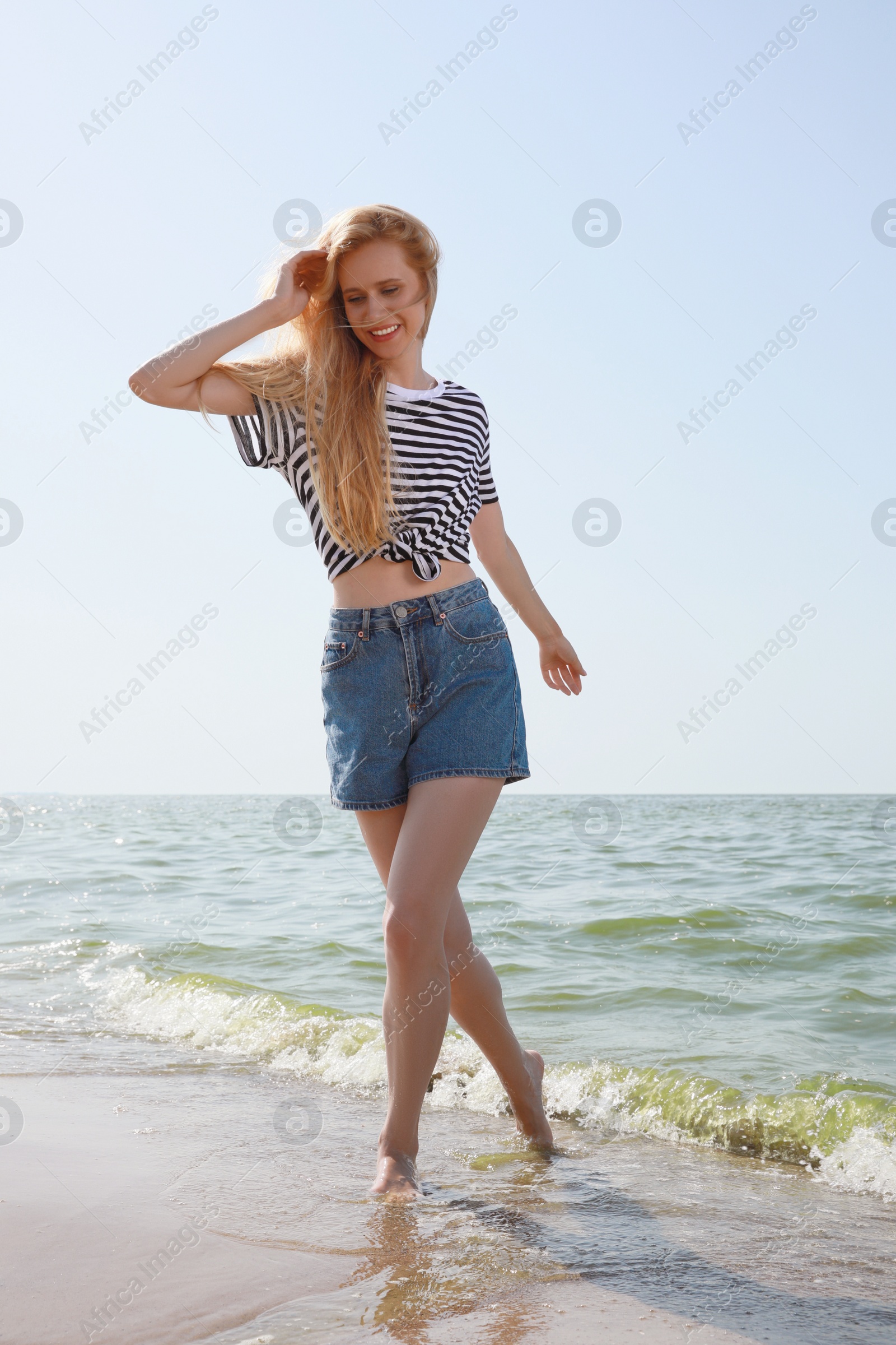 Photo of Beautiful young woman near sea on sunny day in summer