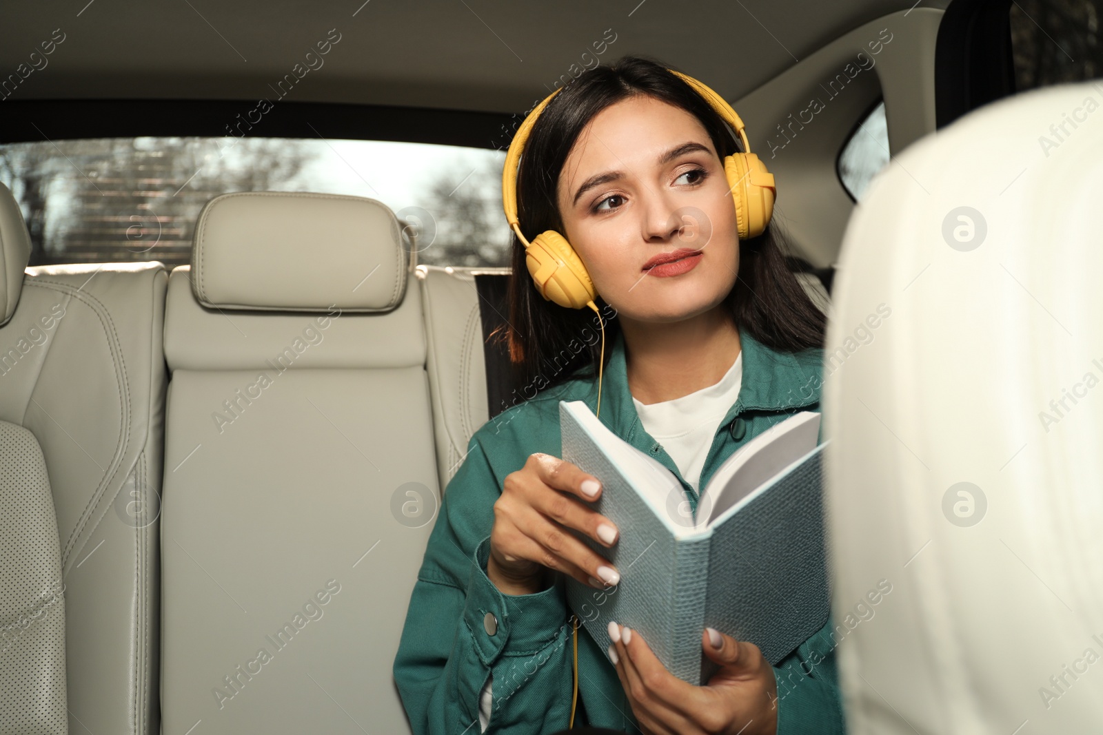 Photo of Young woman listening to audiobook in car