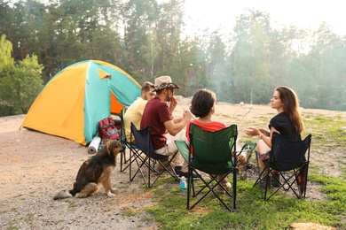 Photo of People having lunch near camping tent outdoors