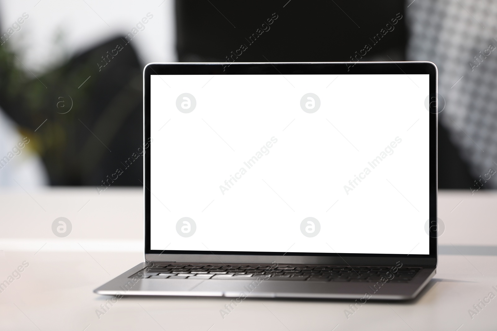 Photo of Modern laptop on white desk in office. Mockup for design