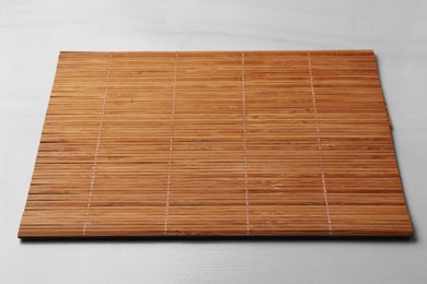 Photo of New clean bamboo mat on beige table