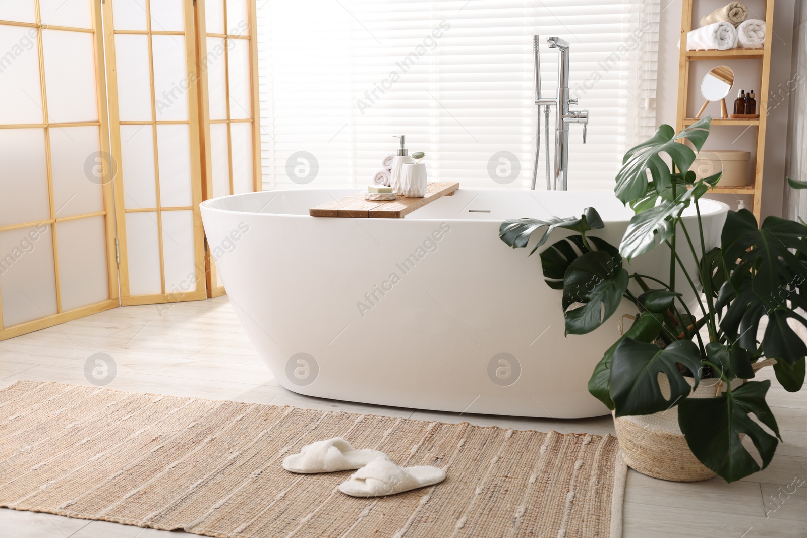 Photo of Different personal care products on bath tub in bathroom