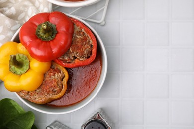 Photo of Delicious stuffed bell peppers on white tiled table, flat lay. Space for text