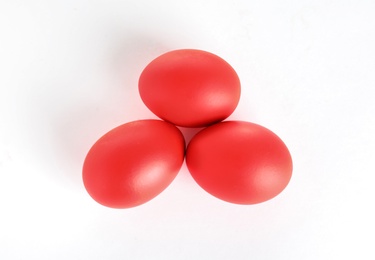 Red dyed Easter egg on white background, top view