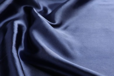 Photo of Crumpled dark blue silk fabric as background, closeup