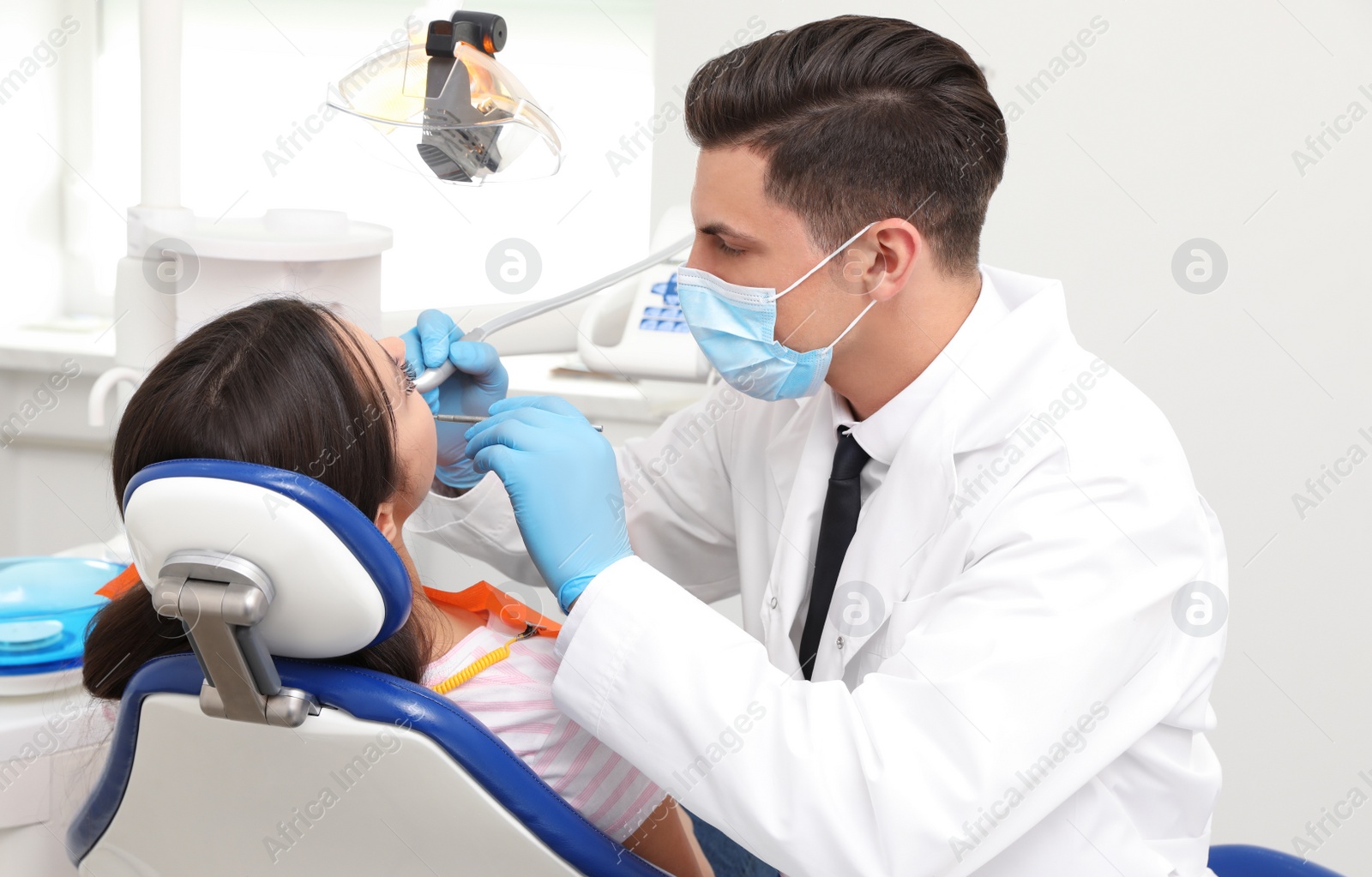 Photo of Professional dentist working with patient in clinic