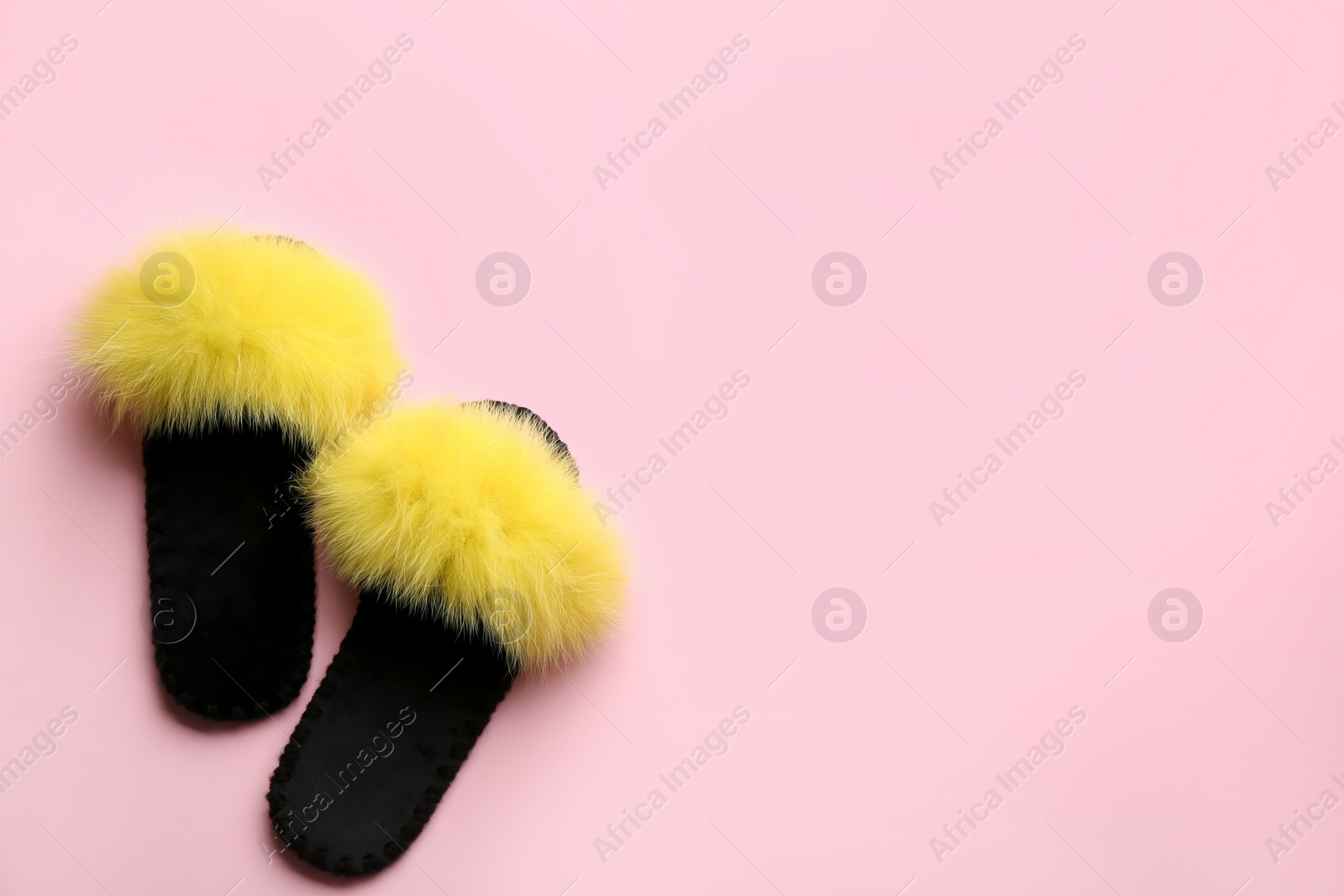 Photo of Pair of soft slippers on light pink background, flat lay. Space for text