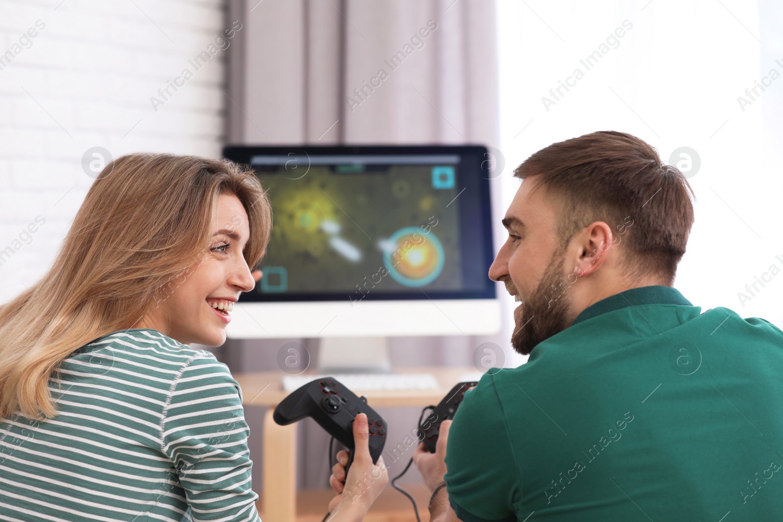 Photo of Young couple playing video game at home