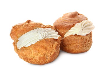 Photo of Delicious profiteroles with cream filling on white background