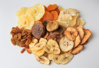 Photo of Pile of different dried fruits on white background, top view
