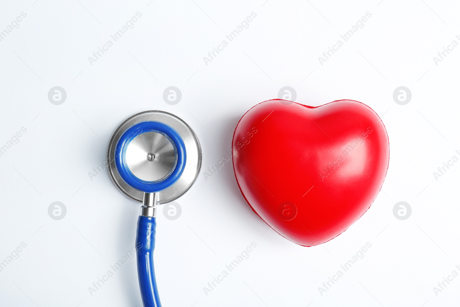 Photo of Stethoscope and heart model on light background, top view. Medical equipment