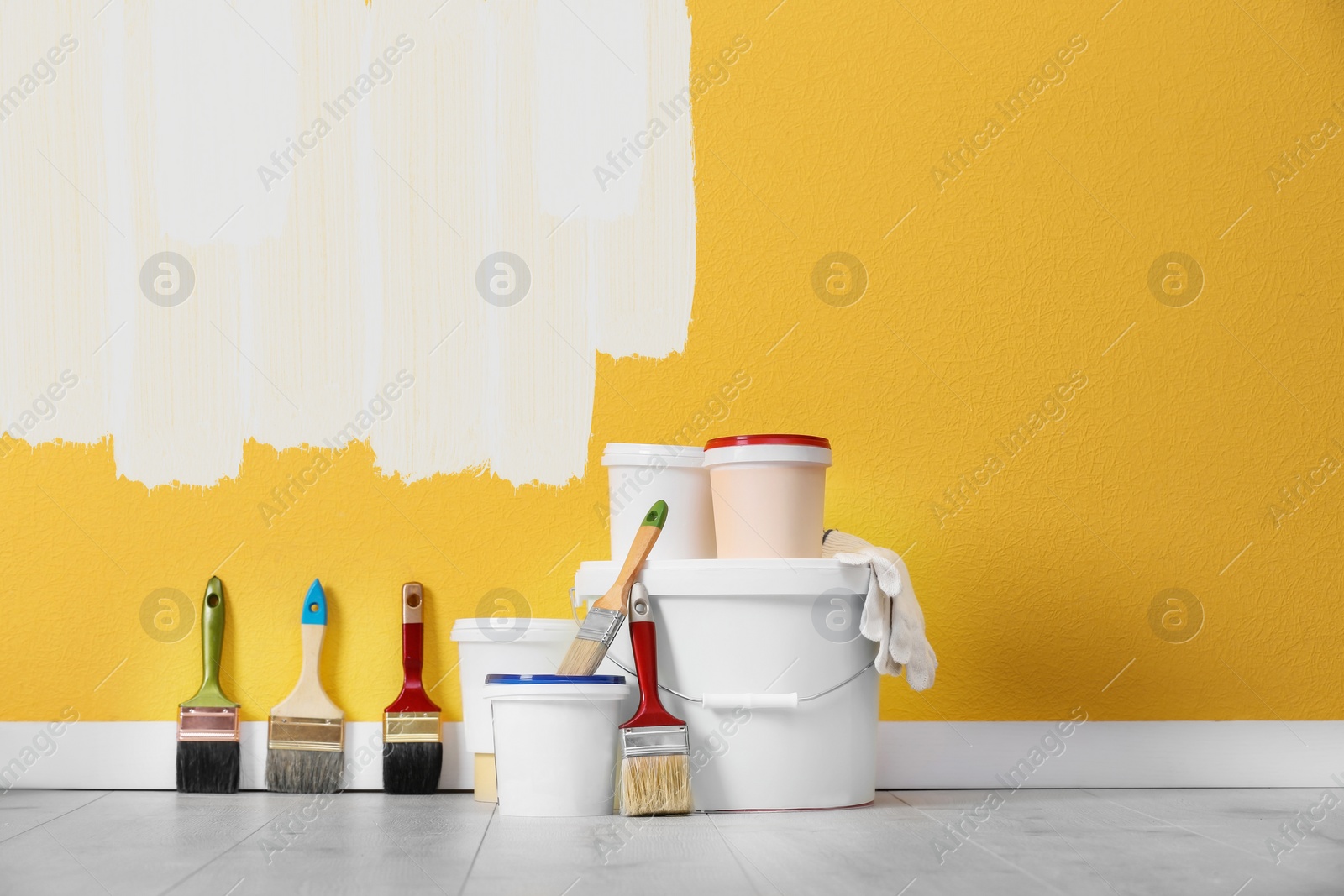 Image of Set with decorator tools and paint on floor near color wall