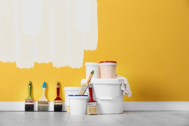 Image of Set with decorator tools and paint on floor near color wall