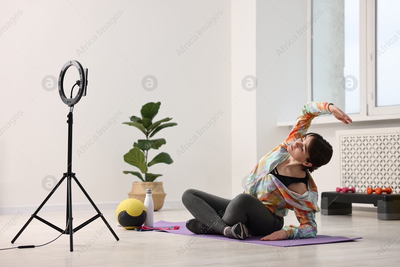 Photo of Happy sports blogger streaming online fitness lesson at home