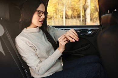 Photo of Emotional woman checking time on watch in car. Being late concept