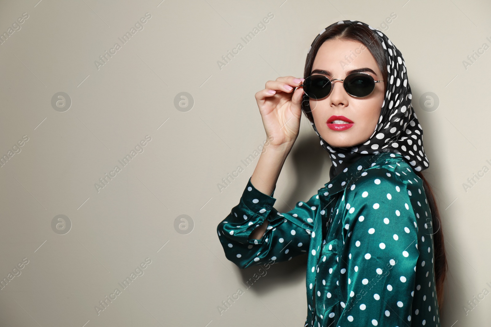 Photo of Beautiful woman in stylish sunglasses on beige background. Space for text