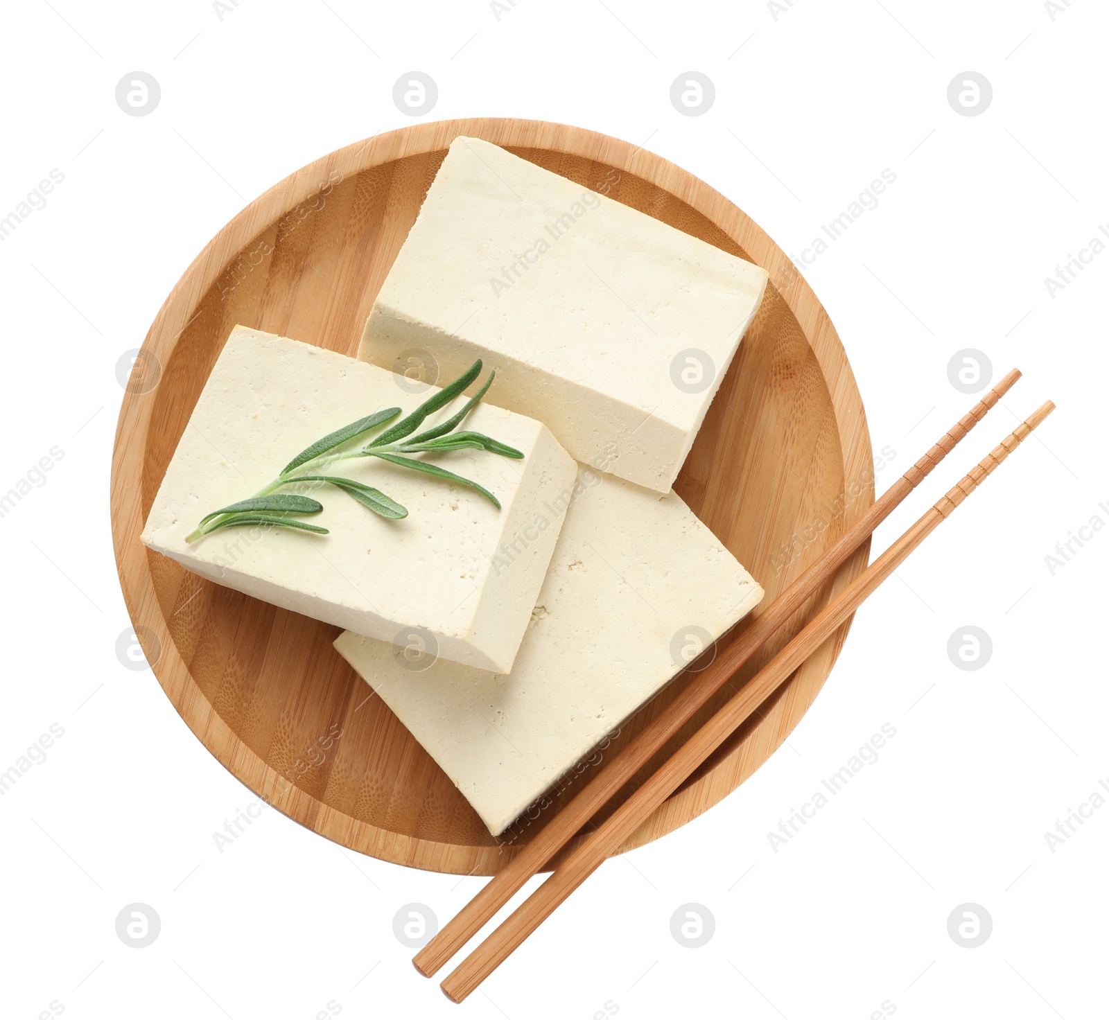 Photo of Wooden plate with delicious raw tofu, rosemary and chopsticks on white background, top view