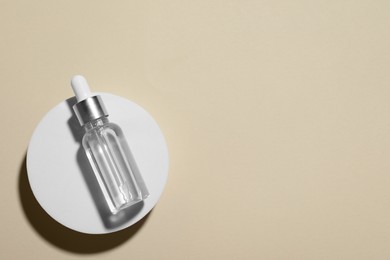 Photo of Bottle of cosmetic oil on beige background, top view. Space for text