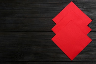 Photo of Clean napkins on wooden table, flat lay. Space for text