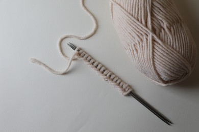 Photo of Soft yarn, knitting and metal needles on light background, top view