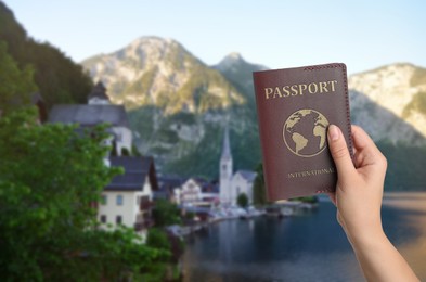 Image of Woman with international passport and beautiful view of town near mountains on background