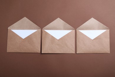 Photo of Paper envelopes on brown background, flat lay