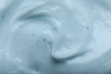 Photo of Closeup view of light blue body cream as background