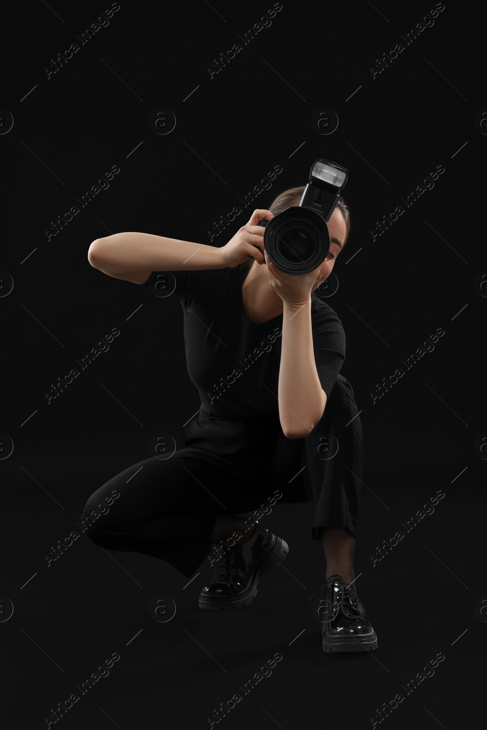 Photo of Professional photographer taking picture on black background
